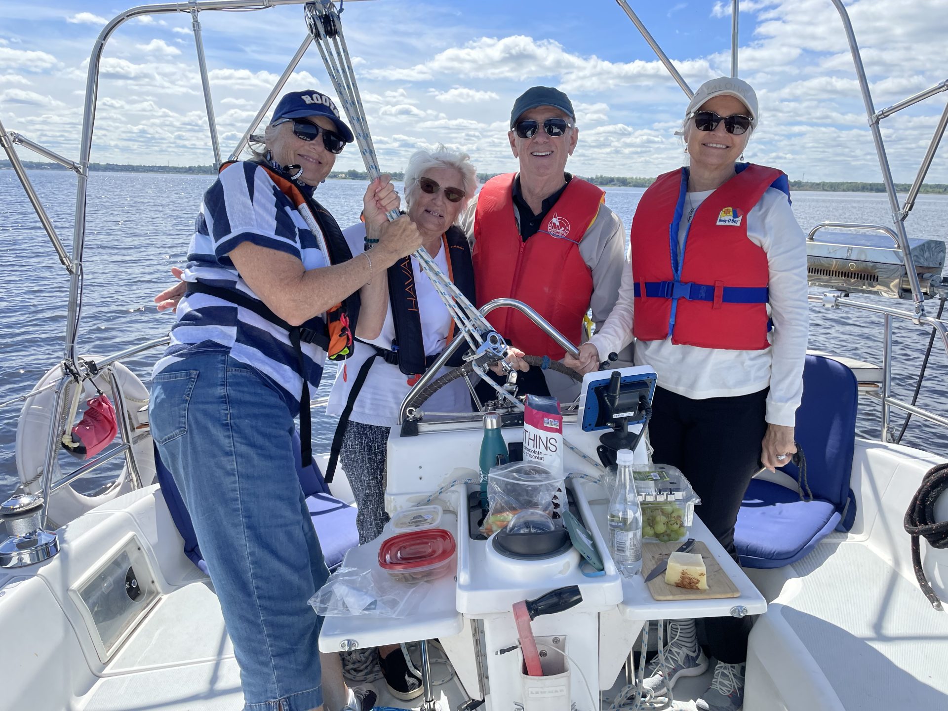 4 people sailing standing at the stern 