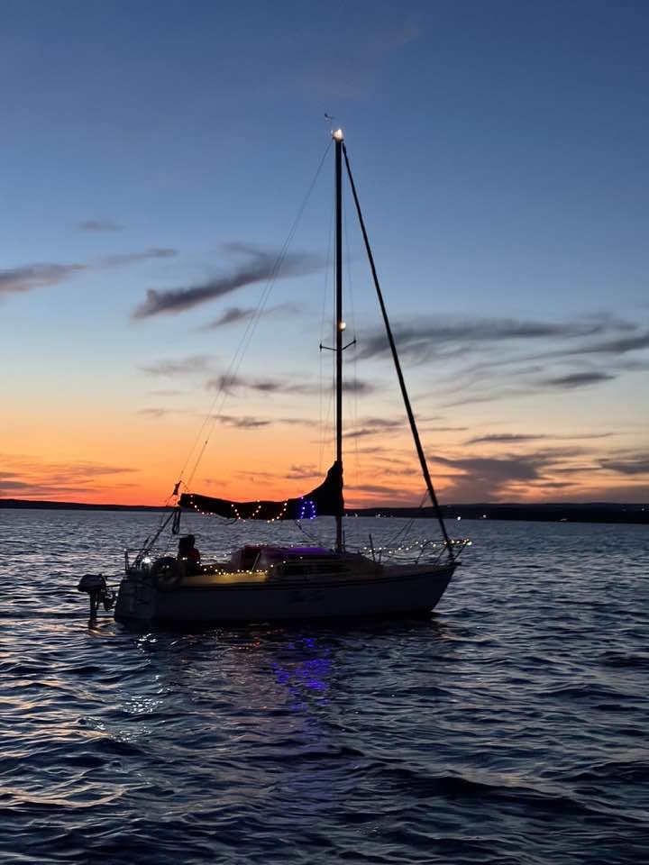 A boat motoring across the sunset.