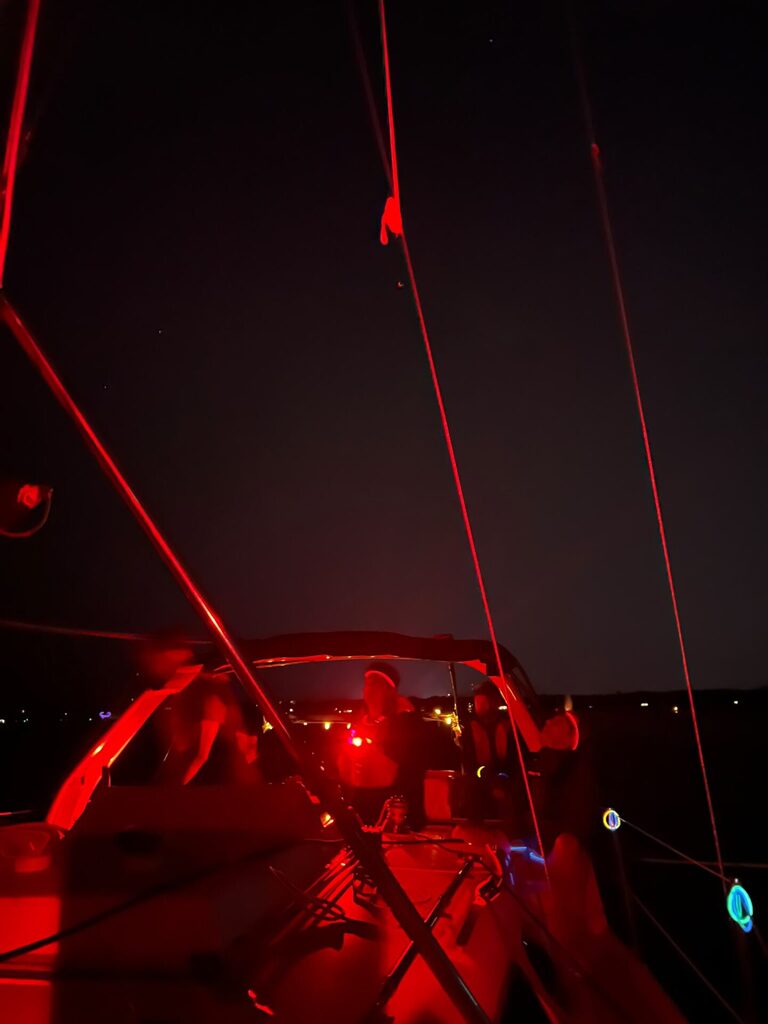 A boat deck and cockpit illuminated with red light.
