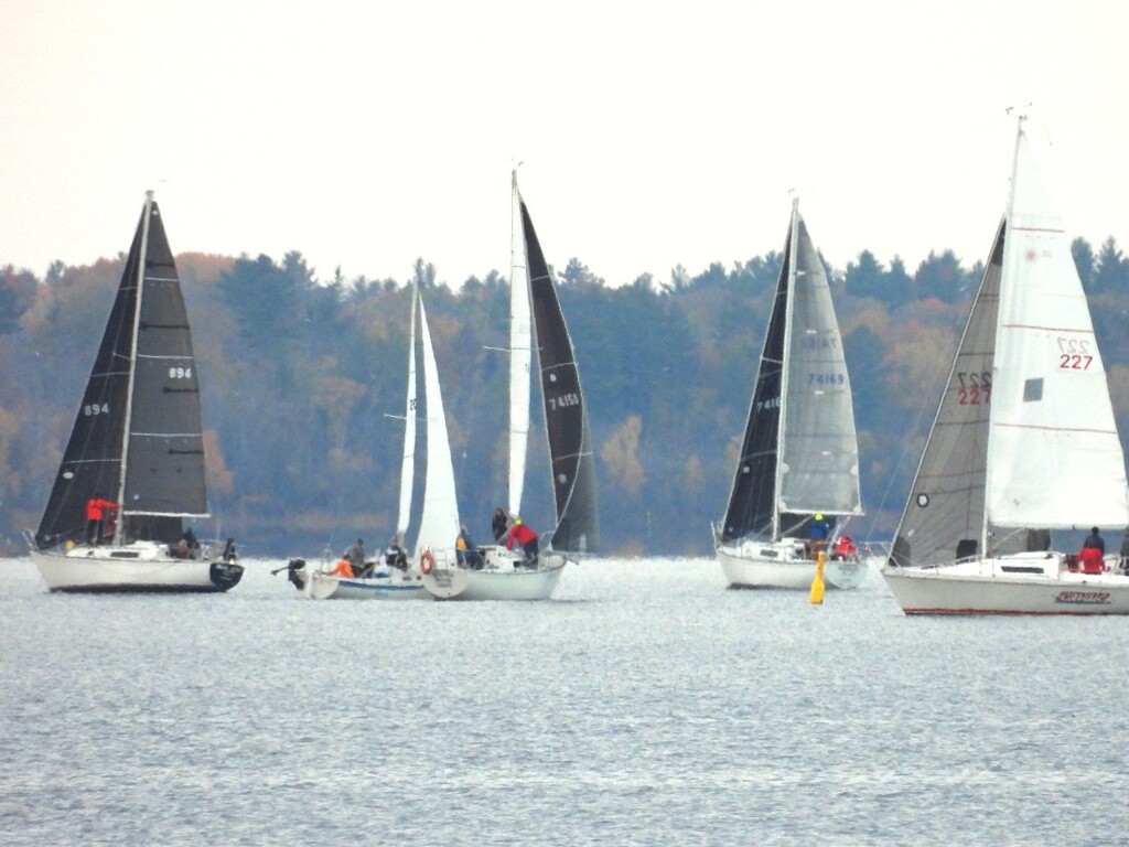 Sailboats sailing near a yellow race mark