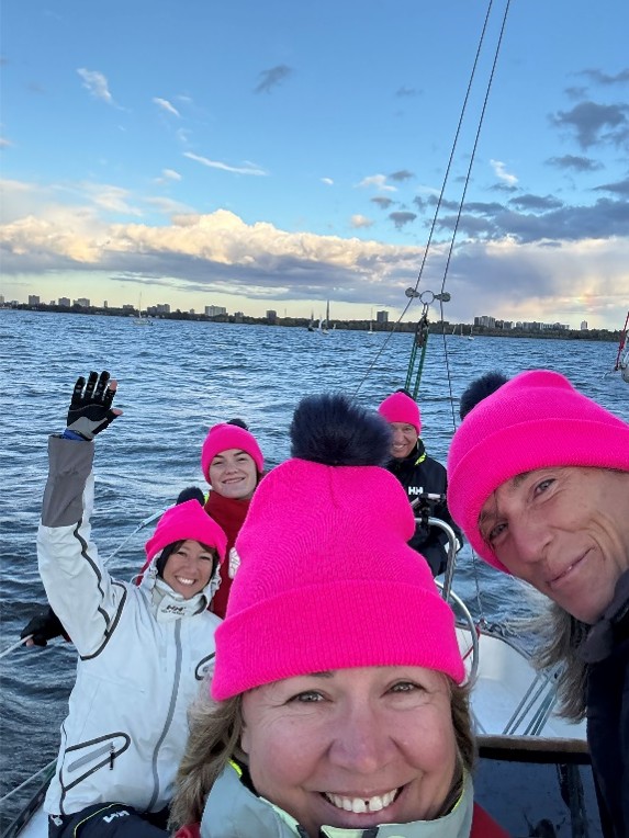 A sailing crew in the cockpit of a sailboat