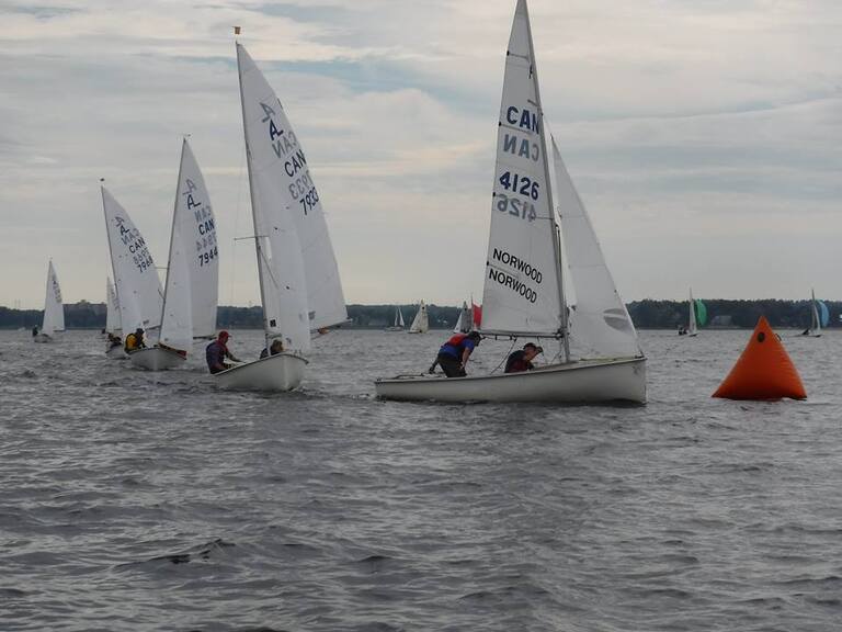 dinghy sailboats racing to a marker