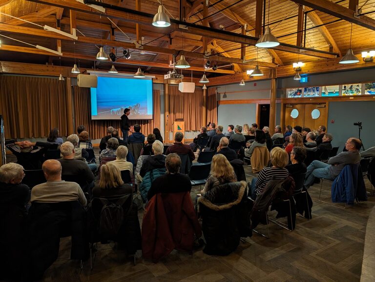 An audience listens to a speaker
