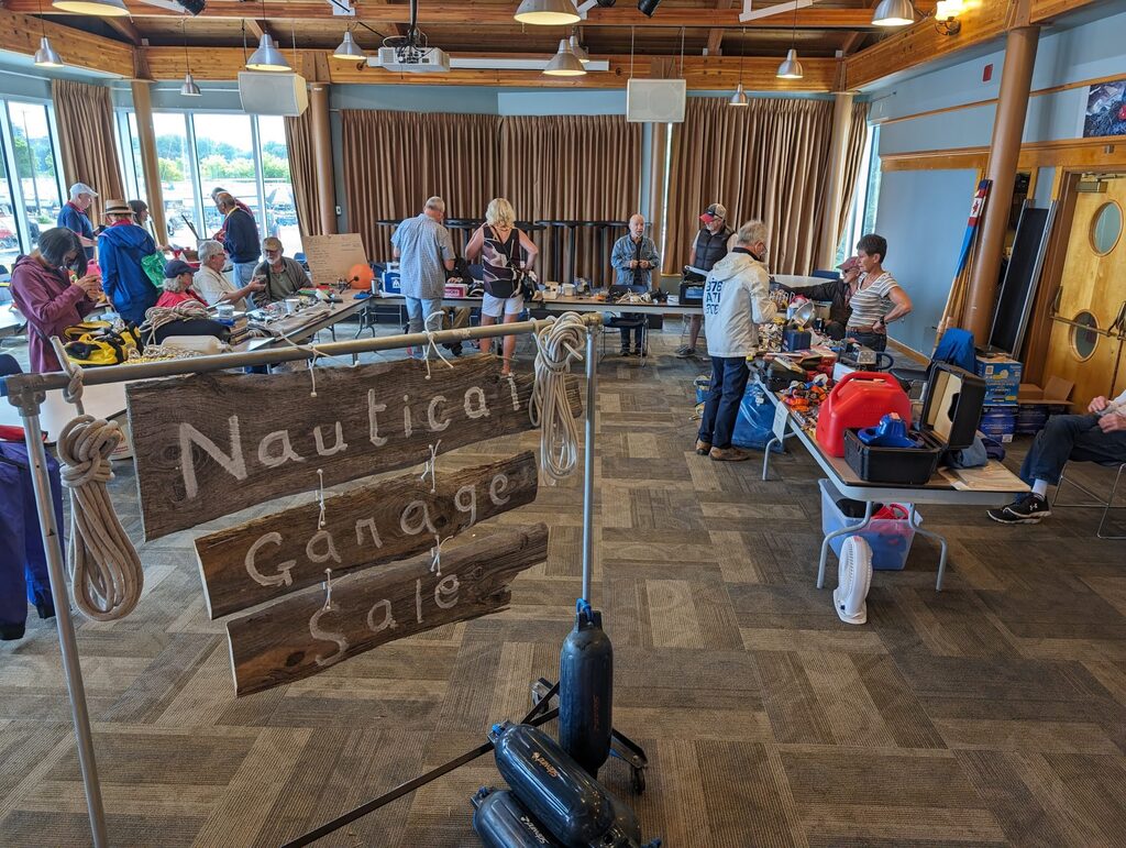 People mill around indoor garage sale tables