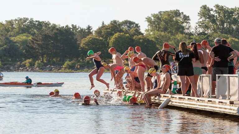 Swimmers jumping off the dock