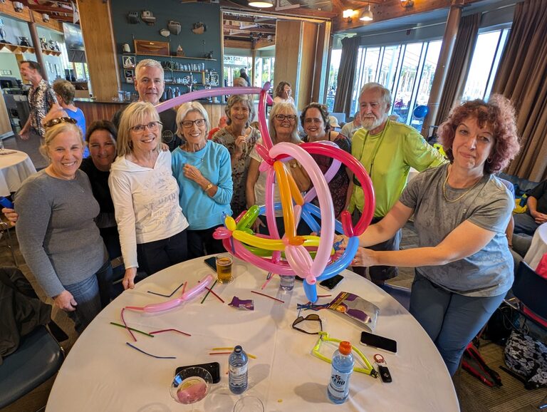 A team of people making a sailboat out of balloons