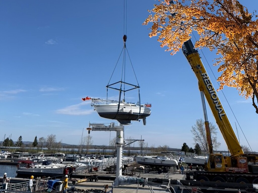 A boat is "flying" through the air lifted by a crane